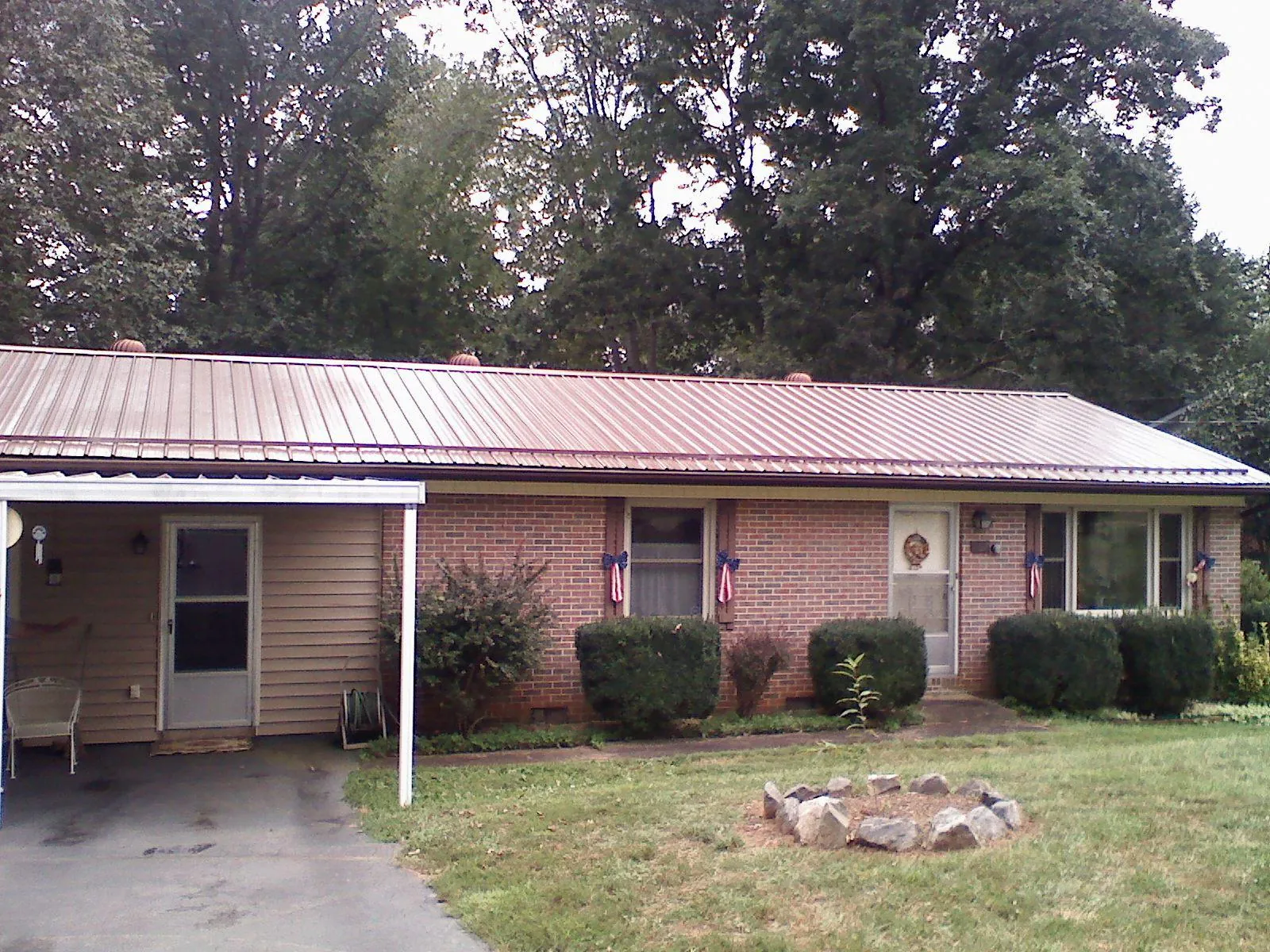 Bronze metal roof and carport on a brick ranch home — Roof Repair work by our crew in Fall Creek
